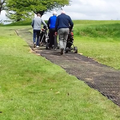 Golfers using rubber grass mat path